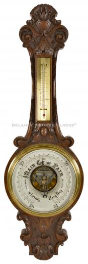 A very unusual carved walnut case aneroid barometer. 222101.