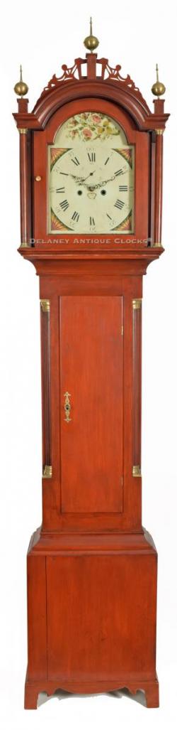 A birch wood case tall clock made in central New England. This is a country form and it retains its original red wash finish. 218049.